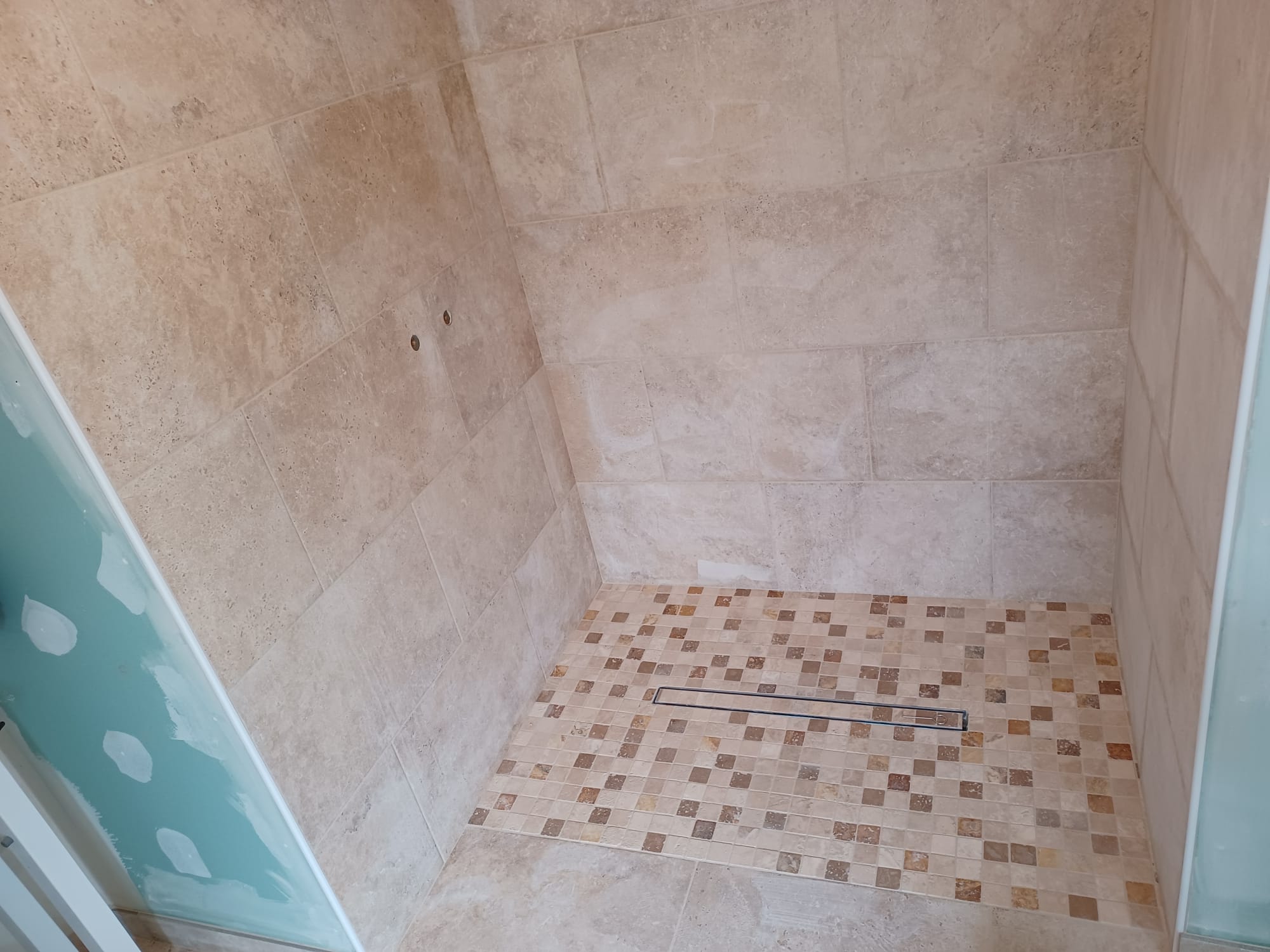 Douche à l'italienne : fusion de fonctionnalité et de style - Juganu Rénovation - Nous nous engageons à transformer vos idées en réalisations concrètes, assurant le succès et les délais de chaque projet. Notre expertise dans le secteur du bâtiment nous permet de vous offrir des solutions sur mesure, combinant innovation et qualité. 