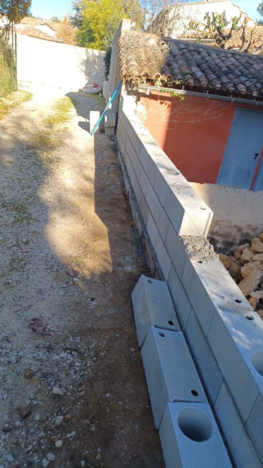 Construction d’un mur de soutènement pour sécurisation et aménagement du terrain - Juganu Rénovation - Nous nous engageons à transformer vos idées en réalisations concrètes, assurant le succès et les délais de chaque projet. Notre expertise dans le secteur du bâtiment nous permet de vous offrir des solutions sur mesure, combinant innovation et qualité. 